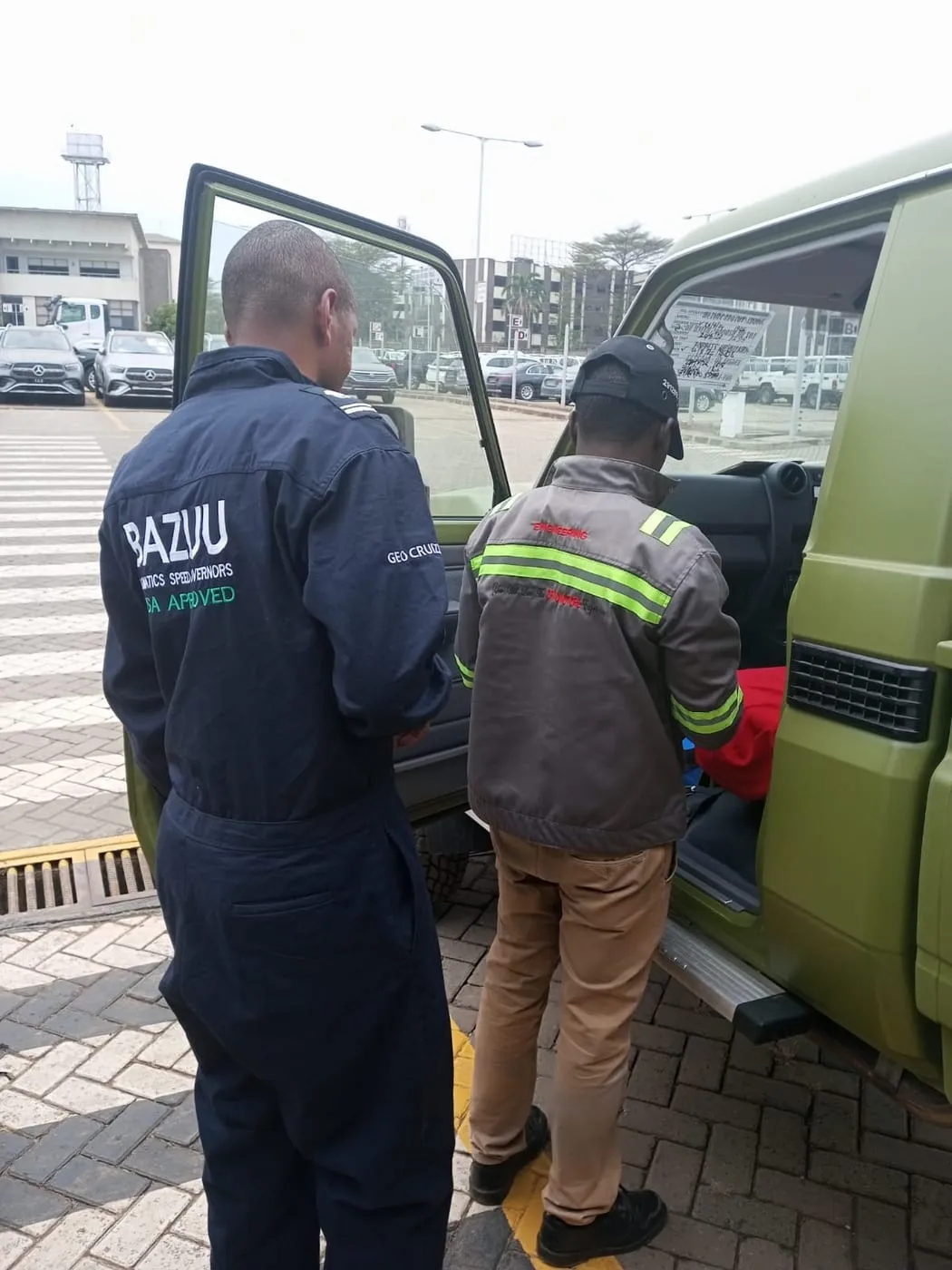 Bazuu technicians fitting a unit to a green fleet vehicle